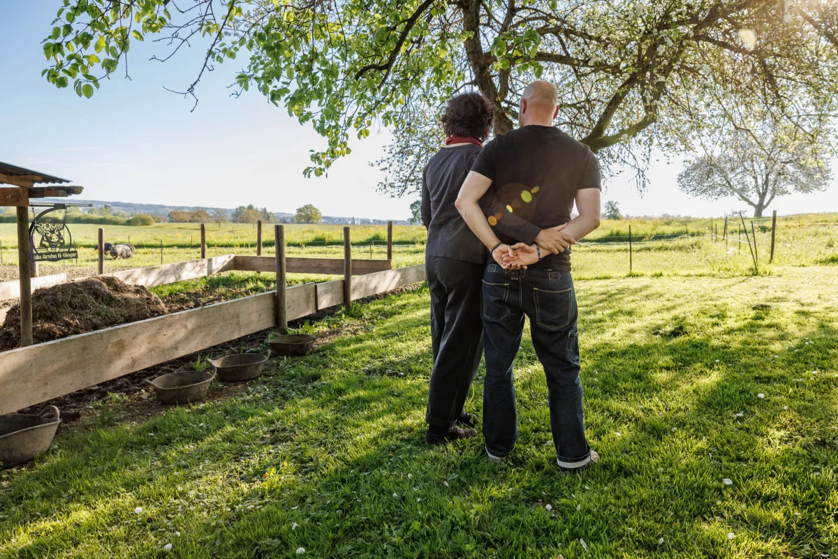 Sandra Neff und Sam Boonkue im Ökoversum Garten mit Blick in die Natur