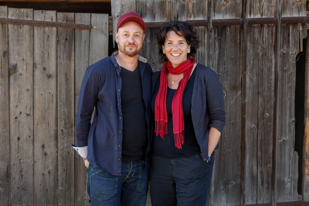 Sandra Neff und Sam Boonkue vom Ökoversum vor einer Holzwand in Schönholzerswilen