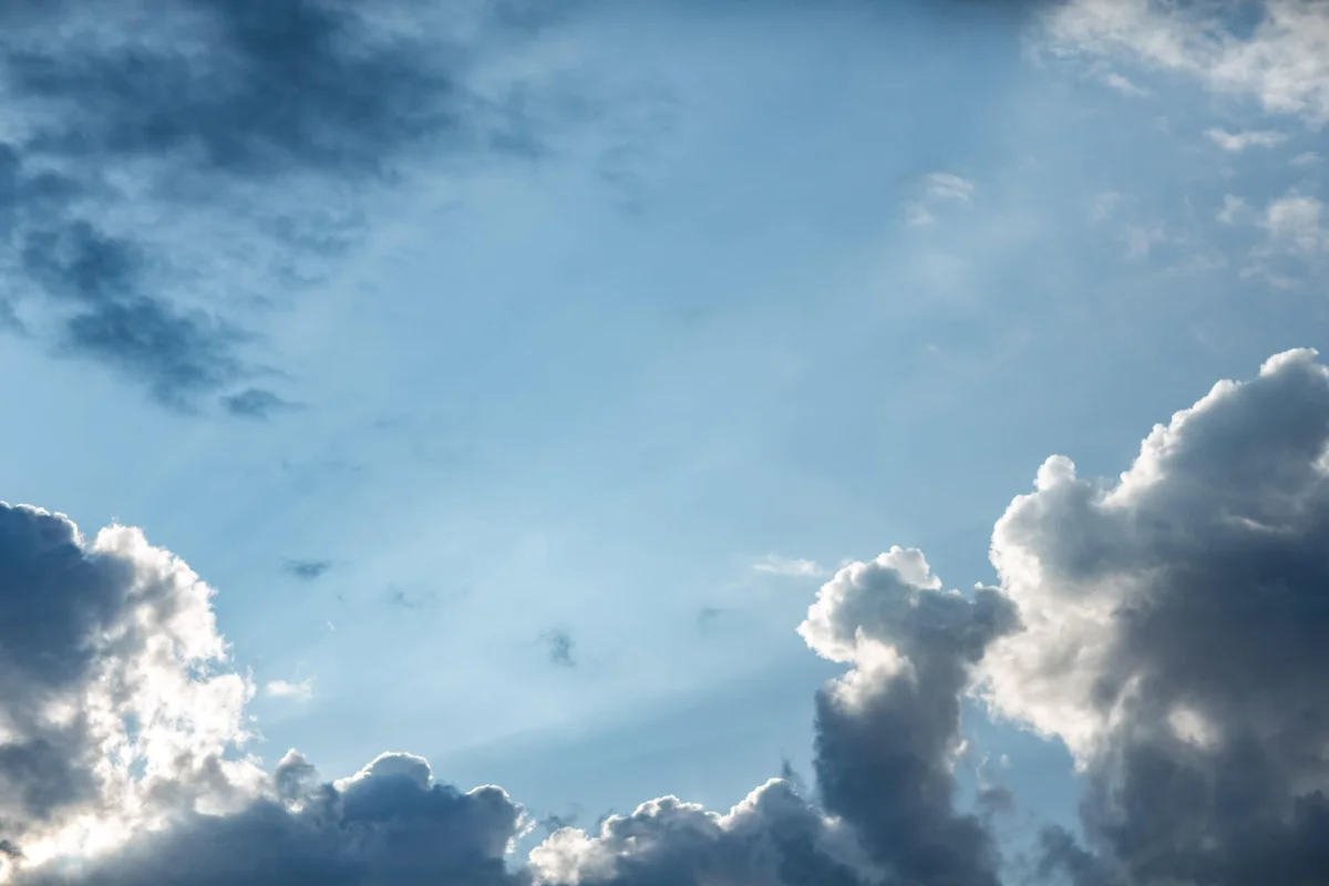 Licht zwischen Wolken und blauem Himmel als Sinnbild für Ruhe, Weite und Auftanken in der Meditation