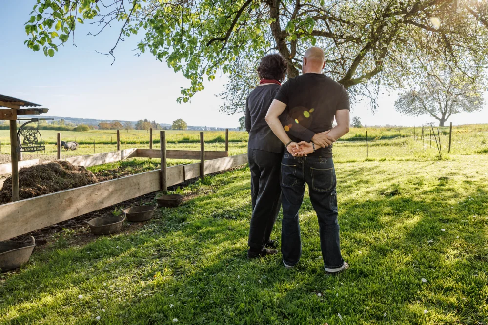 Sandra Neff und Sam Boonkue im Ökoversum Garten mit Blick in die Natur